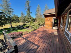 Restored log cabin deck in Newberg, Oregon finished with Benjamin Moore WoodLuxe semi-transparent Natural Cedartone stain.