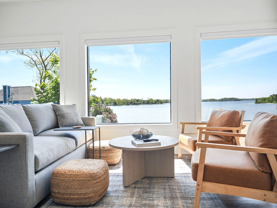 Beautiful beach front cottage, view of living room with large windows and comfortable seating.