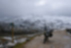 Motorcycle on a snowy mountain road with a wooden signpost. Overcast sky and rugged landscape set a moody atmosphere. AvVida.co.uk - Adventure Motorcycle Travel TET Picos https://maps.app.goo.gl/u28j6ZPeFGHYvANj8