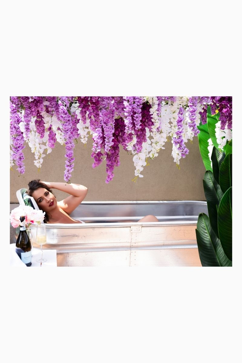 Woman in rustic bathtub on a private rooftop in Calgary boudoir studio.
