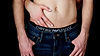 Close up of male torso wearing jeans and armani boxers with female hands wrapped around.