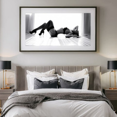 Wall art above the bed featuring black and white boudoir portrait.