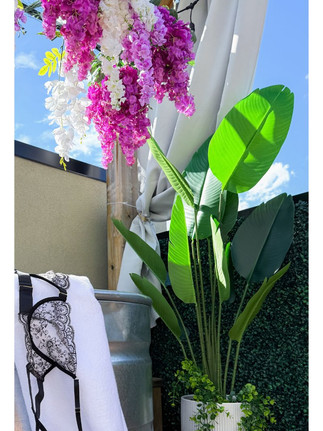 outdoor boudoir rooftop details with purple wisteria flowers and rustic bathtub with ferns