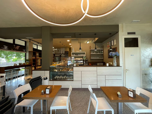 Area tavolini di forno con banco espositivo, mensole e illuminazione circolare di design Novalux.