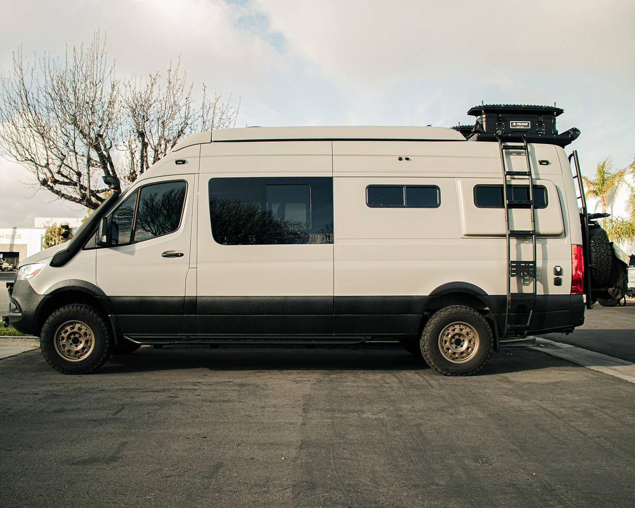 Side view of a Sprinter camper van with LINE-X coated lower body panels at our Corona, CA shop