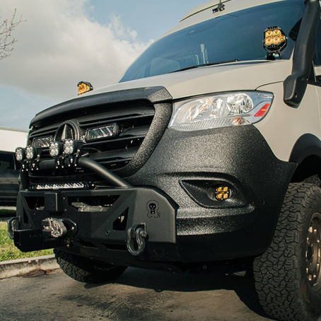 Sprinter van with LINE-X textured black coating on the front bumper and fender flares in Corona, CA