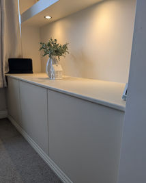 A meticulously designed, expertly crafted, and flawlessly installed media wall that exudes timeless elegance. This bespoke feature includes wall-to-wall base units, offering abundant and practical storage, beautifully backlit display shelves 