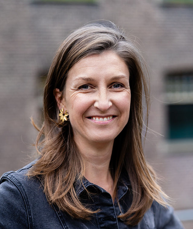 Jonge vrouw kijkt vrolijk recht in les