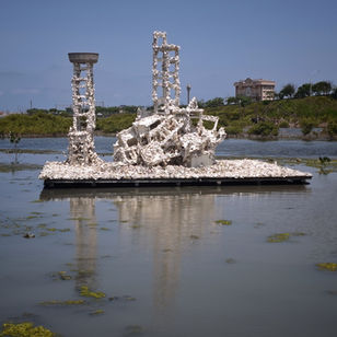 A floating oyster-shell-covered platform in Cheng Long Wetland, with discarded chairs and tables transformed into vertical structures and shelters for migratory birds and small wetland lives.