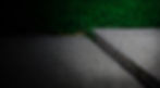 Uneven sidewalk with grass growing in a gap between two concrete slabs
