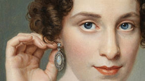 Vintage-style portrait of a woman adjusting an ornate drop earring, illustrating the personal meaning of everyday jewelry.