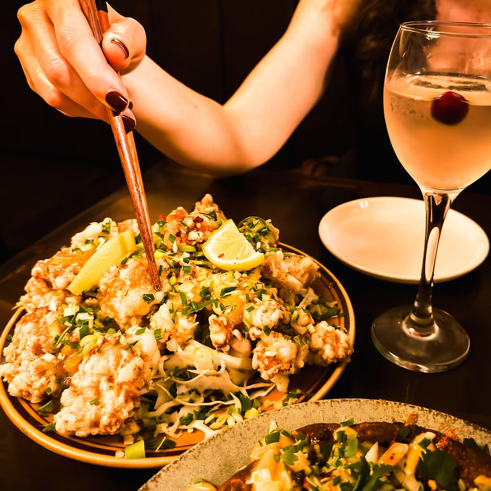 Seoul Travel Guide: Chopsticks going into a plate piled high with fried chicken and a glass of sake at Hangong Gan in Seoul