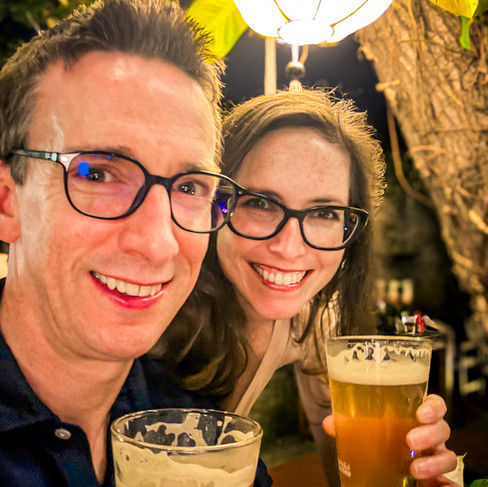 James & Shal holding beers at the 7 Bridges Taproom, one of the best things to do in Hoi An at night - grab a pint!