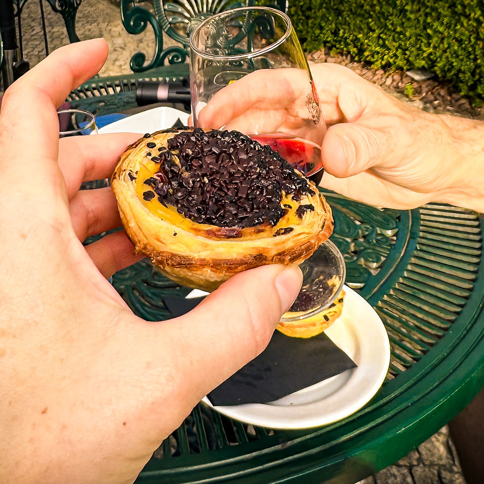 Shal toasting James with a pastel de nata in the rose garden at Taylor's Port Cellars in Porto.