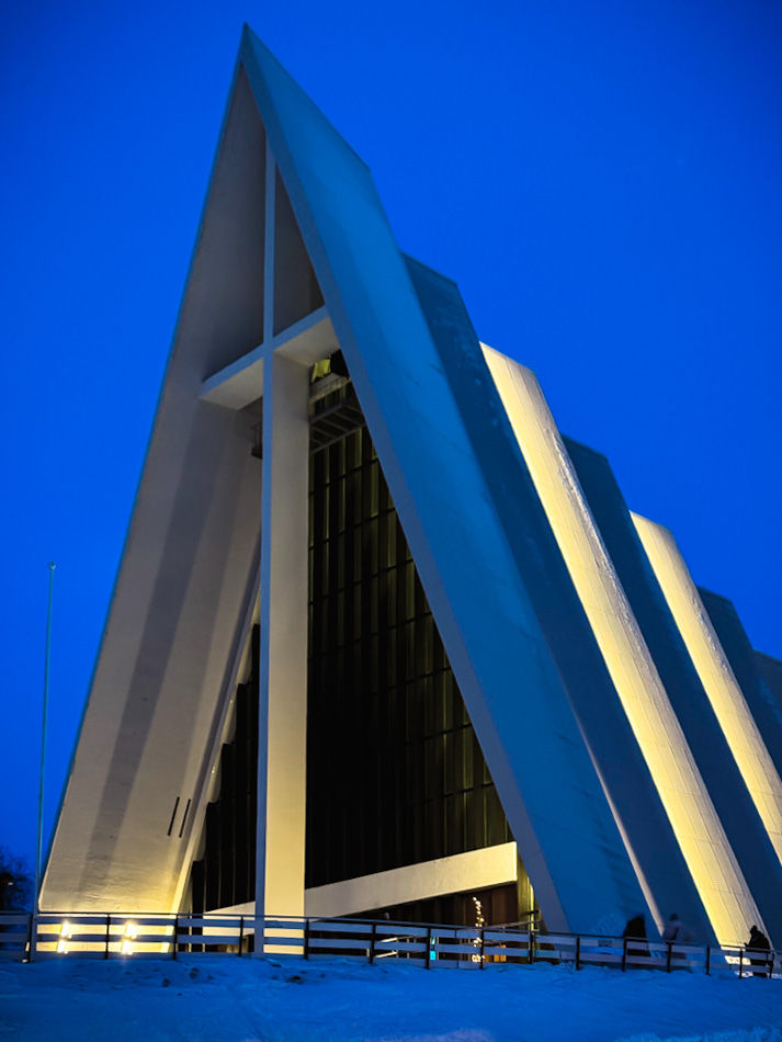 Arctic cathedral lit up against a dark blue sky during blue hour. A must-see on any Tromso itinerary.