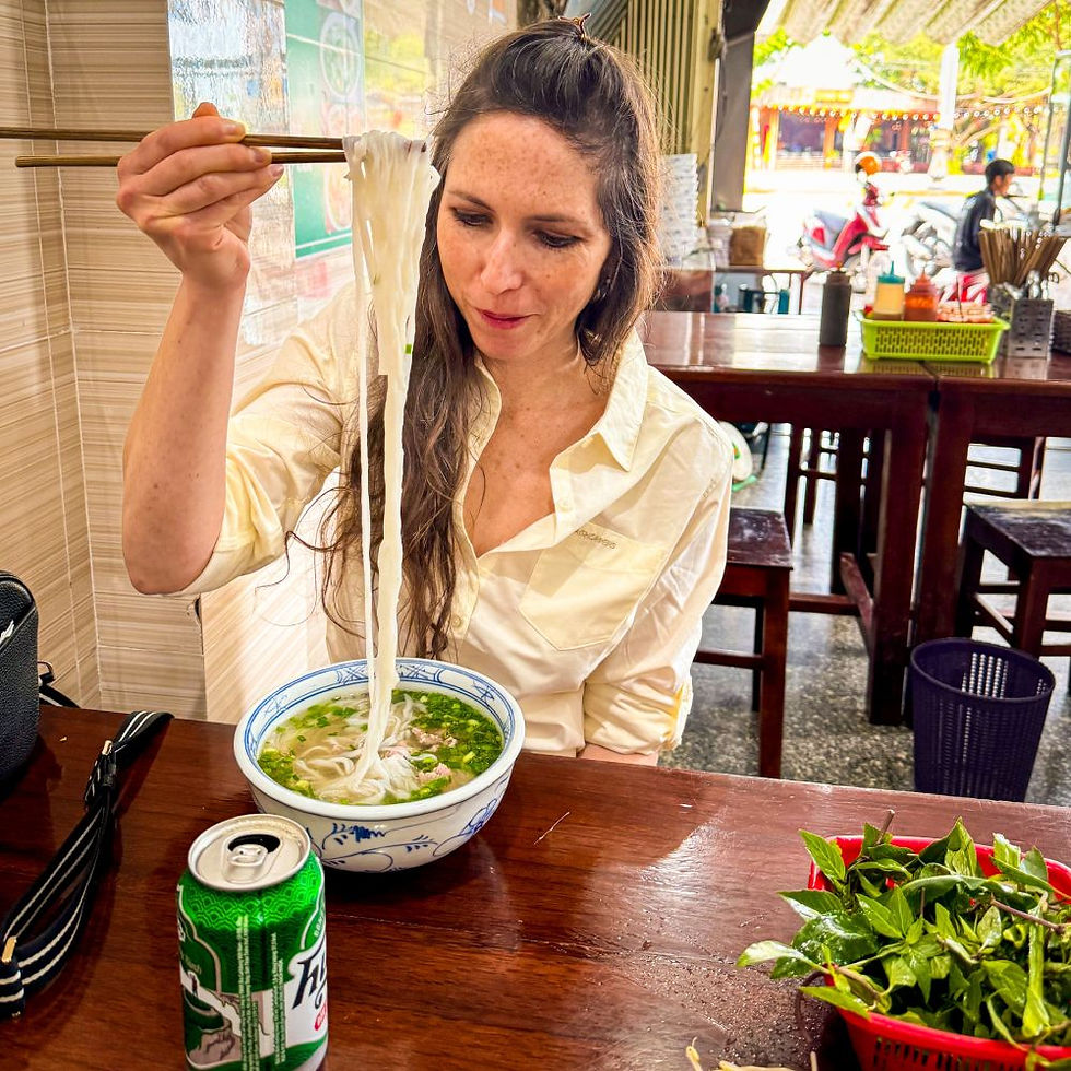 Shal examining noodles at a super local pho shop on a private My Son Sanctuary tour from Hoi An.