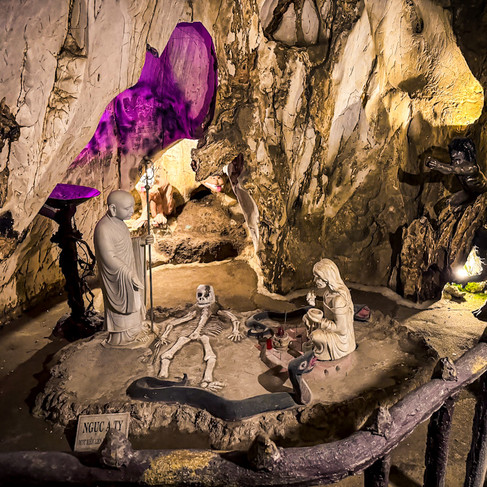 Buddhist statues inside Am Phu Cave depicting punishment and repentance, visited as part of a My Son Sanctuary Tour from Hoi An.