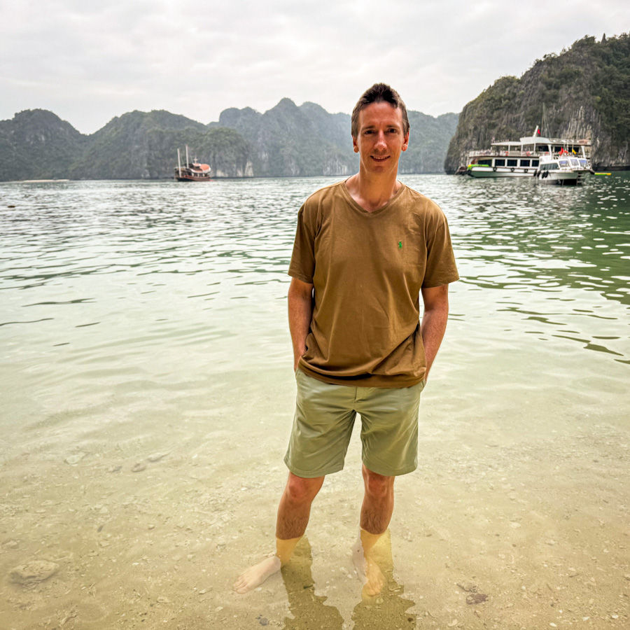Three Peaches Islet: Too chilly to swim, but perfect for chilling. James braving the water like a legend on this tiny beach that only shows up at low tide. Part of our day trip on our 2 night Ha Long Bay cruise