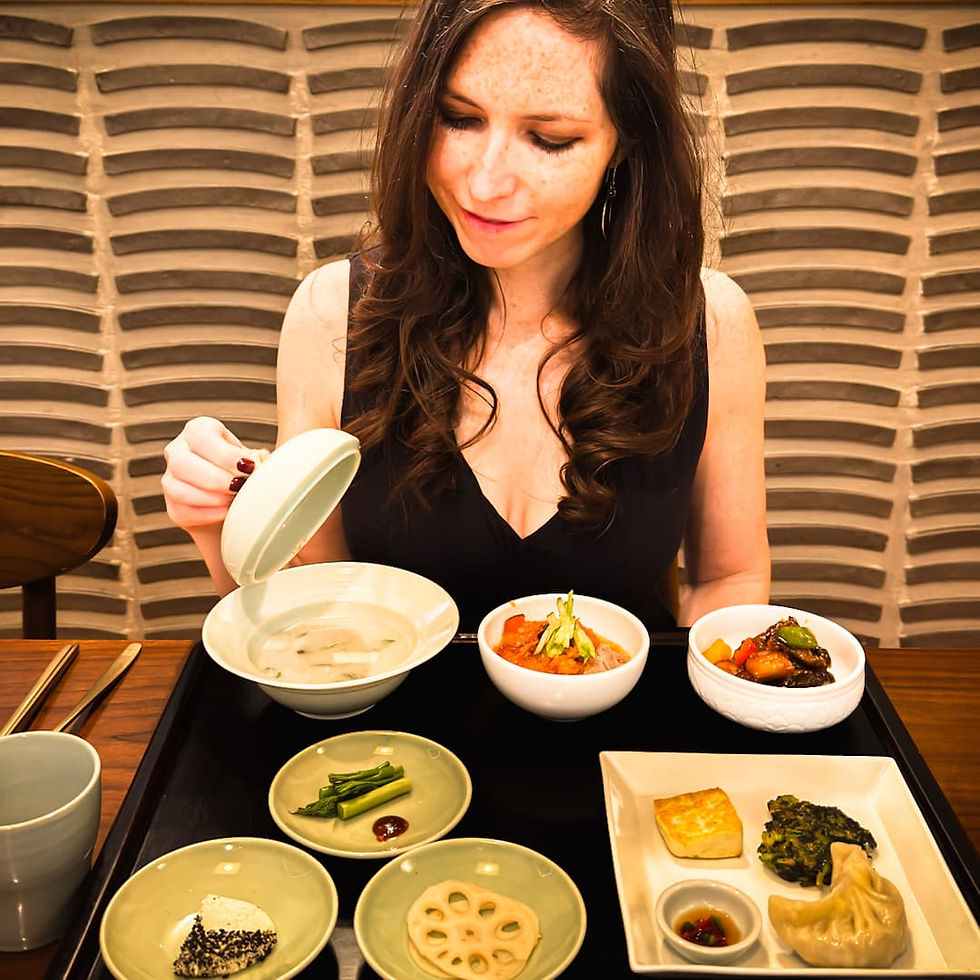 Shal lifting the top of a bowl of porridge at Balwoo Gongyang in Seoul