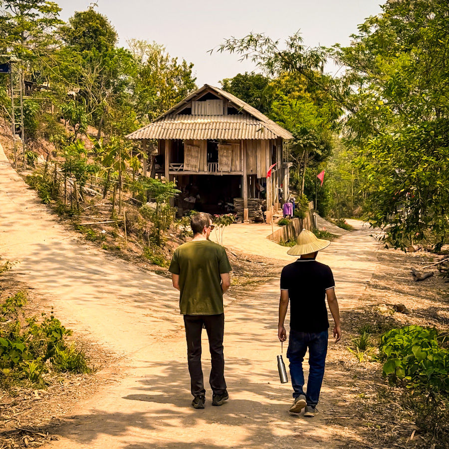 James and our guide walking through Co Cham, a tiny community we visited with one dirt road, 35 families, and a daily rhythm dictated by the sun, the seasons, and the occasional wandering buffalo.