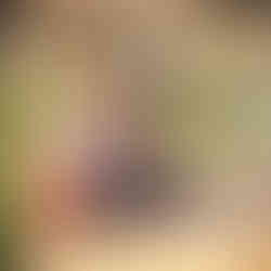 James and Shal sitting on a bamboo raft on a calm river at Suoi Cham, with lush greenery and hills in the background. Suoi Cham is a bonus after seeing the most beautiful rice fields in Vietnam.