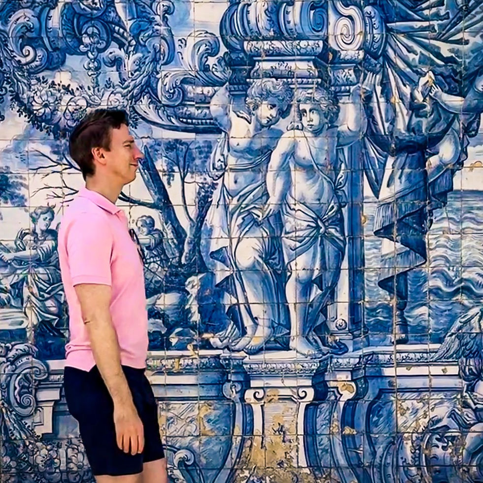 James walking past azulejos featuring expressive cherub statues in the upper courtyard of the cloister in Porto Cathedral (Sé do Porto) in Portugal.