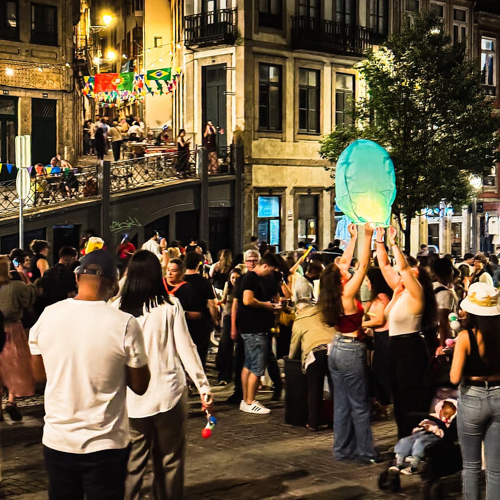 Porto Travel Tips: Don't miss Sao Joao. Street filled with people holding plastic hammers and trying to release large paper lanterns into the sky.