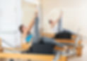 Concentrated young girl practicing exercises on Pilates reformer with sitting box. Concept