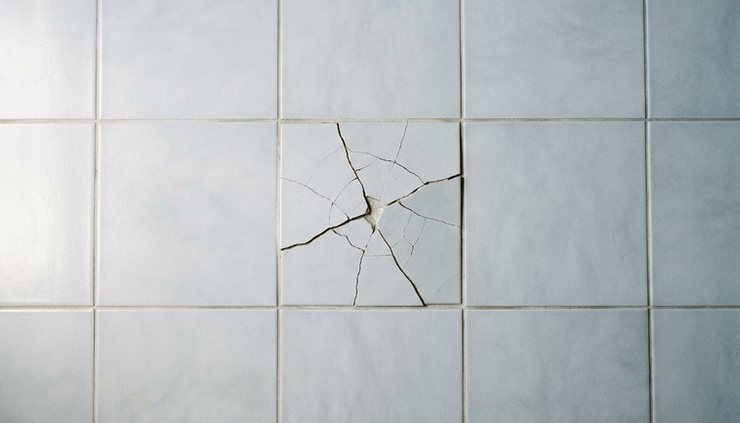 Overhead view of a single cracked tile in an otherwise finished floor