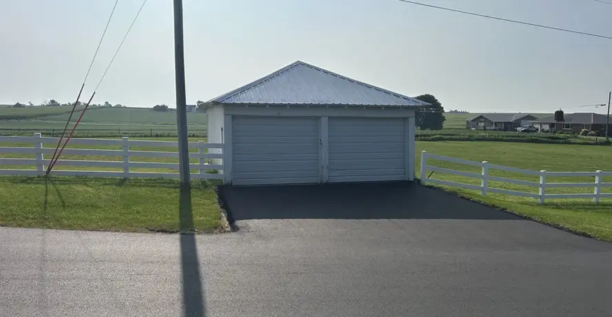 New asphalt driveway leading up to a detached residential garage near Dubuque, Iowa.