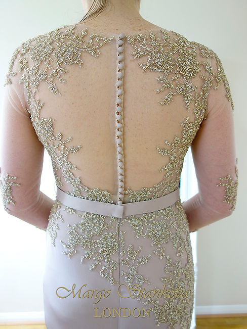 close up back view to a luxury couture beaded wedding dress illusion back with buttons in pink color