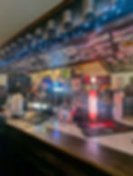 The bar of The Toucan, with international money decorating the roof and bartenders ready to pour some pints.