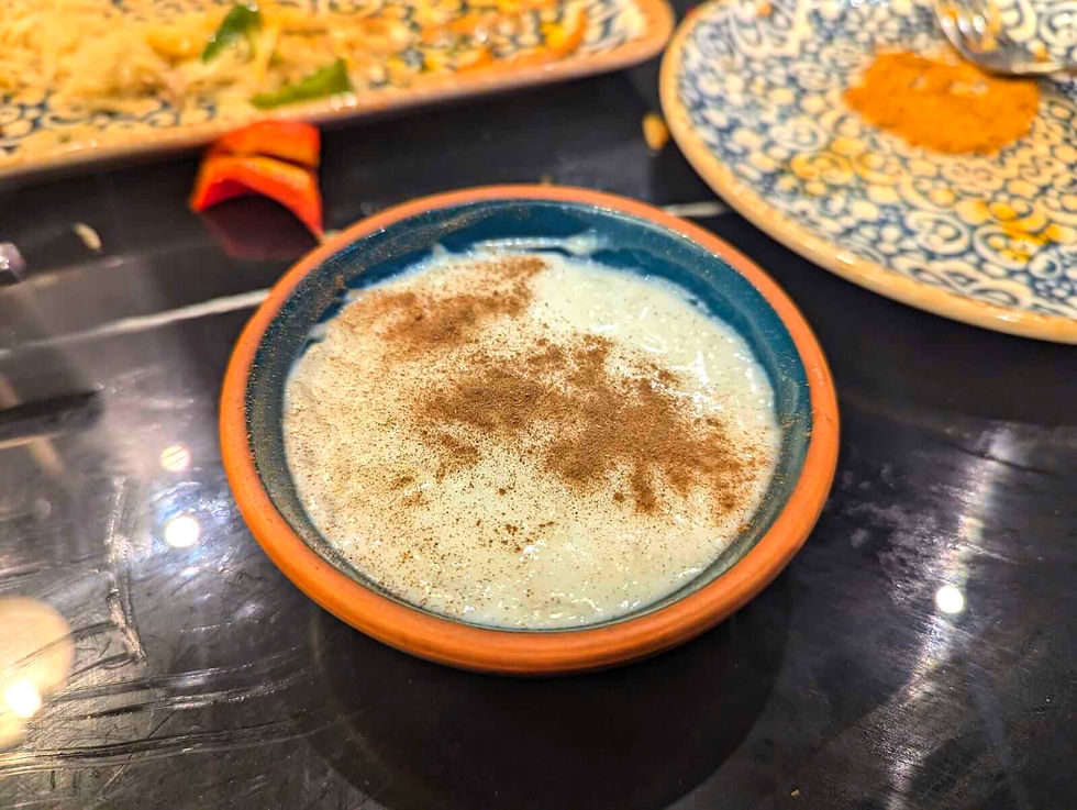 A bowl of traditional Xinjiang-style rice pudding topped with a dusting of cinnamon powder.