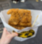 A fried chicken ji pai in take away paper covered in spices