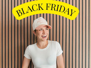 A woman wearing a hat with a Black Friday sign and slatted bachground.