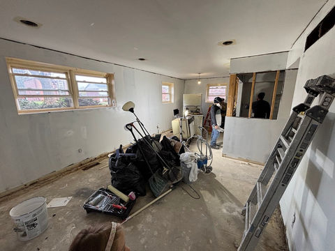Living space tear-out in a smoke-damaged apartment, removing old flooring, stained walls, and outdated fixtures for a full renovation.