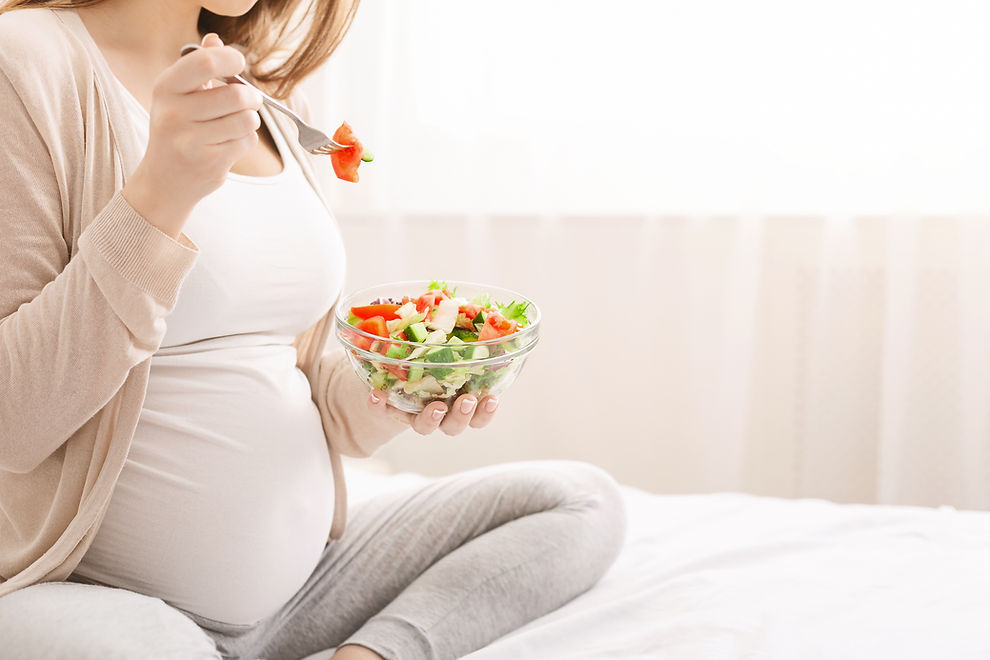 Healthy diet. Pregnant woman eating fresh vegetable salad in bed, free space.jpg