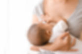 Mother breastfeeding her newborn baby beside window. Milk from mom’s breast is a natural m