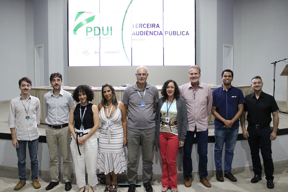 Pessoas em pé posando para a fotografia. Ao fundo, tela exibe o título "Terceira Audiência Pública".