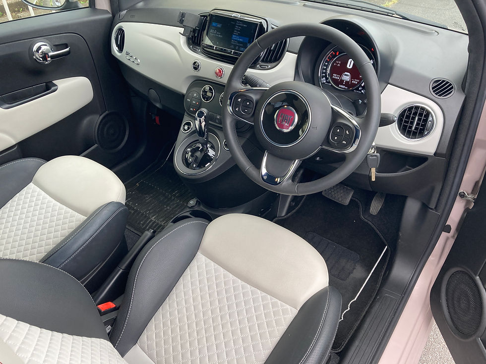FIAT車の右ハンドル車内。白黒のシートとダッシュボード、中央モニター、速度計、キーが見える静かな内装。