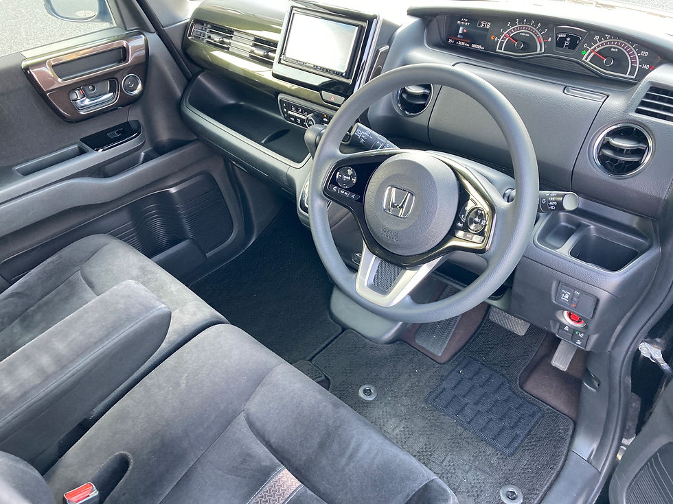 Ｎ－ＢＯＸの内装。運転席とハンドルが黒で覆われ、ダッシュボードにはメーターとスクリーンがあり、整理された印象。ハンドルにロゴ付き。