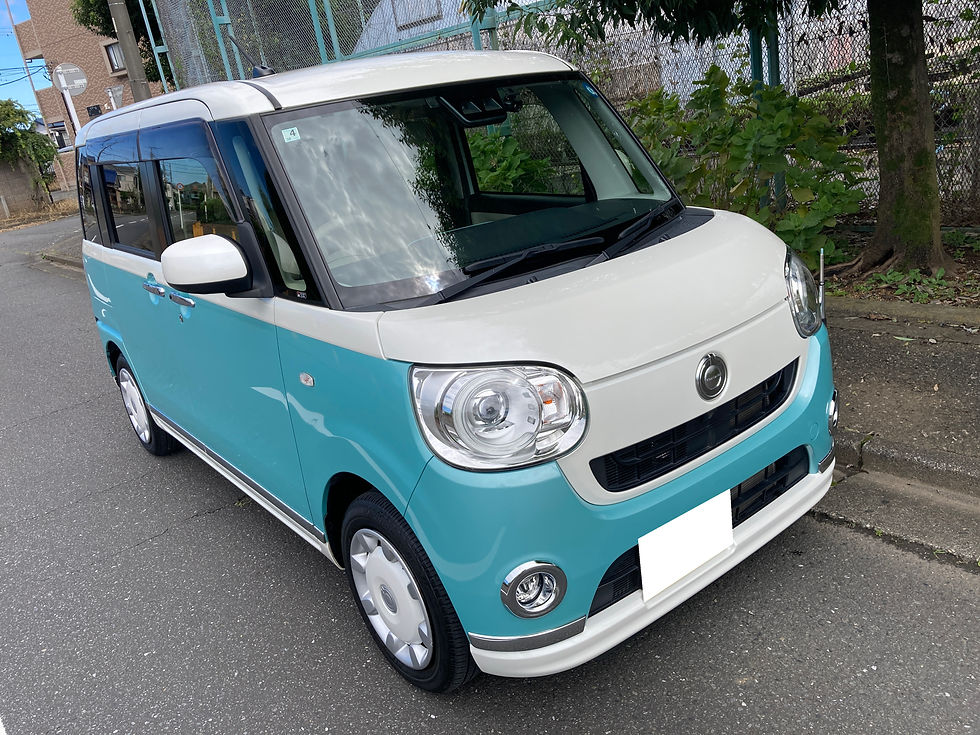 ムーヴキャンバスが住宅街の路上に停車している。前方斜めからの写真で、木やフェンスが背景に見える。