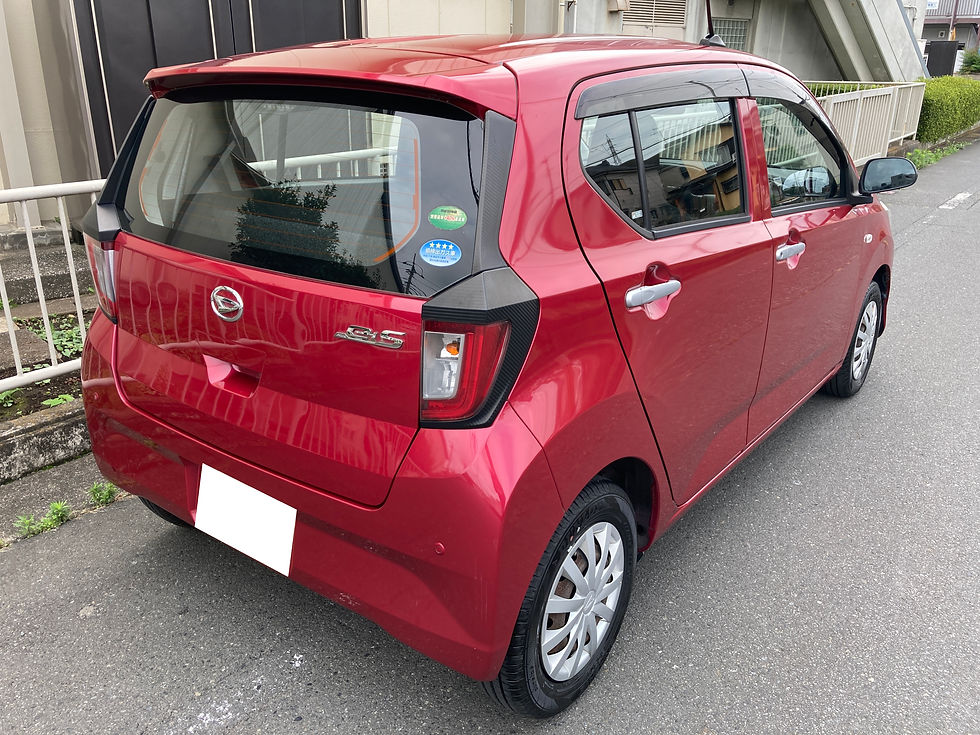 赤いミライースが住宅街の路上に駐車されている。後部に車種エンブレムとステッカーが見え、静かな雰囲気。
