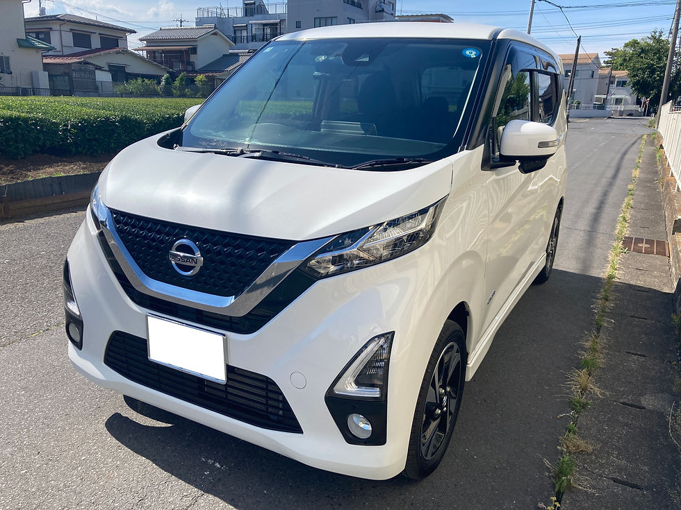 晴れた住宅街の路上に停車した白い日産のデイズ。フロントにNISSANロゴが見え、静かな雰囲気。