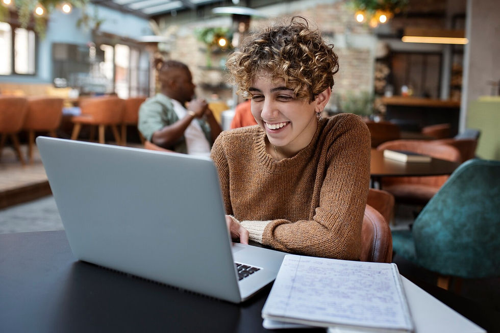a person learning wit laptop and notebook and smiling