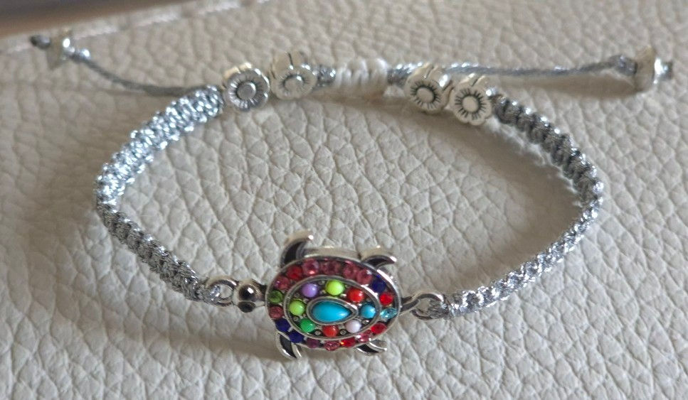 Miniature : Bracelet “Lien de Lumière” sur fond naturel, symbole tortue mis en valeur sur fils cirés argentés.