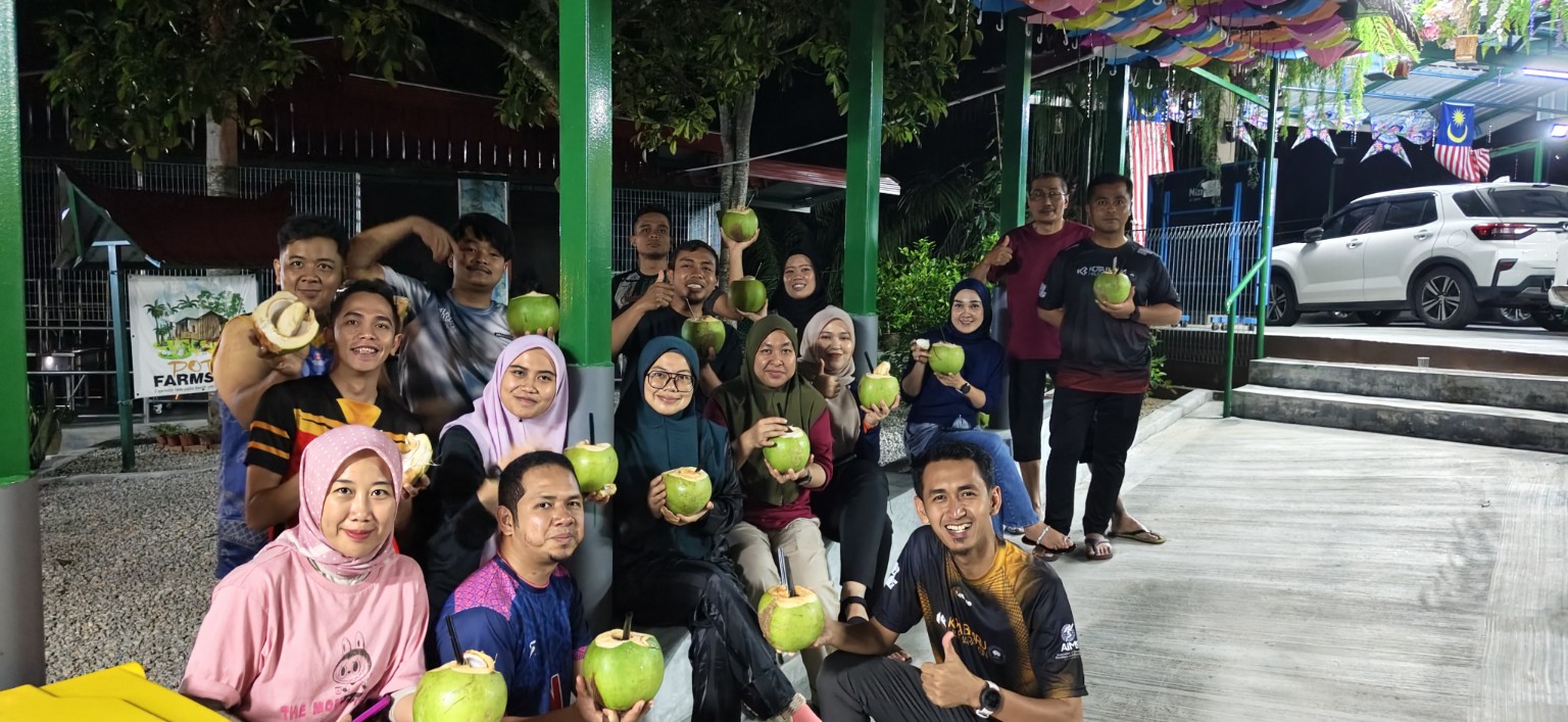 Guests drinking fresh coconuts at Potai Farmstay FELDA Bukit Rokan Gemencheh