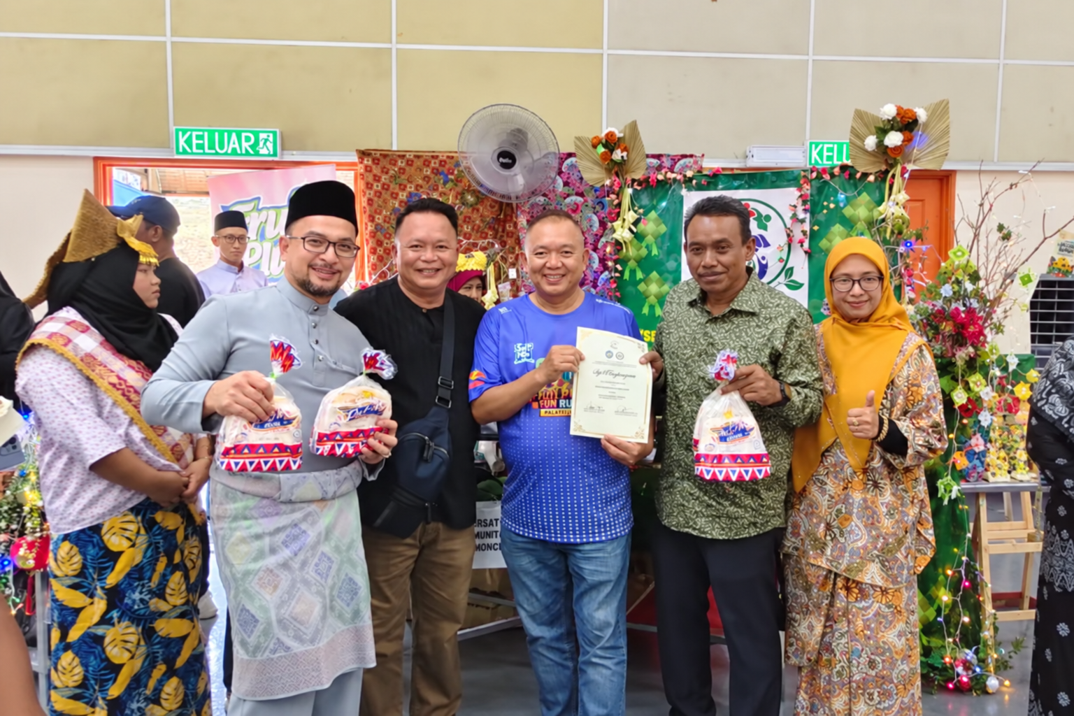 Potai Farmstay founder Calvin Lai Khong Wah Ah Koon with Lai Kong Heng representing Fruit Plus at a FELDA Bukit Rokan community event