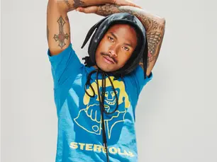 Artist, Steve Lacy with his arms up looking at the camera