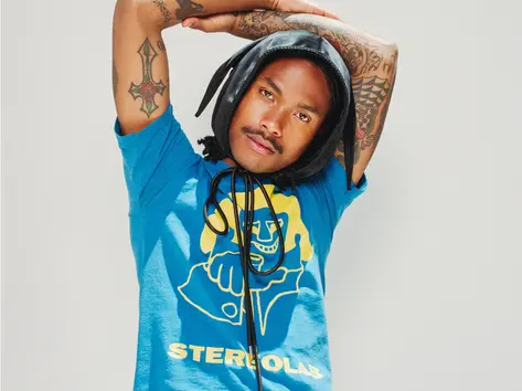 Artist, Steve Lacy with his arms up looking at the camera